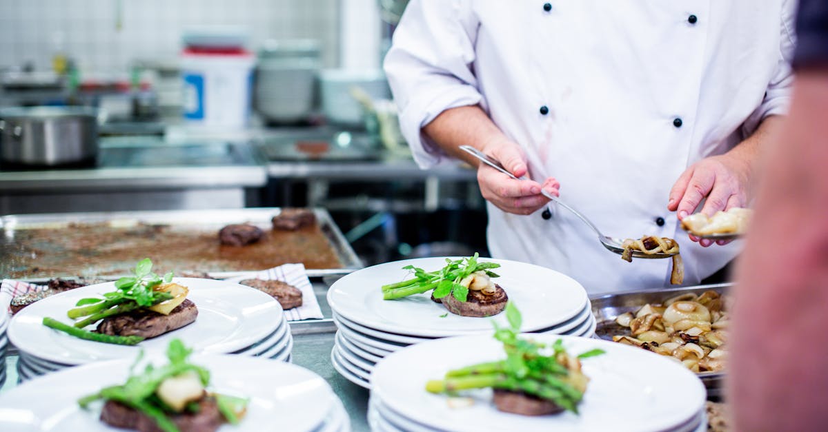 A chef prepares gourmet dishes in a professional kitchen setting, showcasing fine dining elegance.